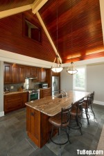 Tủ bếp gỗ Dỗi với màu vân gỗ tự nhiên kiểu dáng chữ L kết hợp với bàn đảo tạo không gian bếp ấm áp – TBT2072